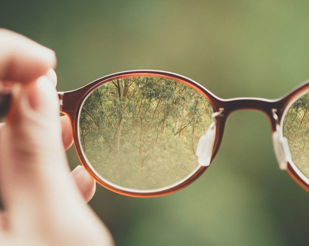 Persona sujetando una montura de gafas graduadas para elegir el modelo adecuado