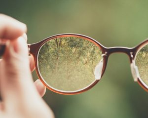 Persona sujetando una montura de gafas graduadas para elegir el modelo adecuado